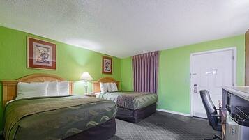 A hotel room with two beds, a desk, and a chair.