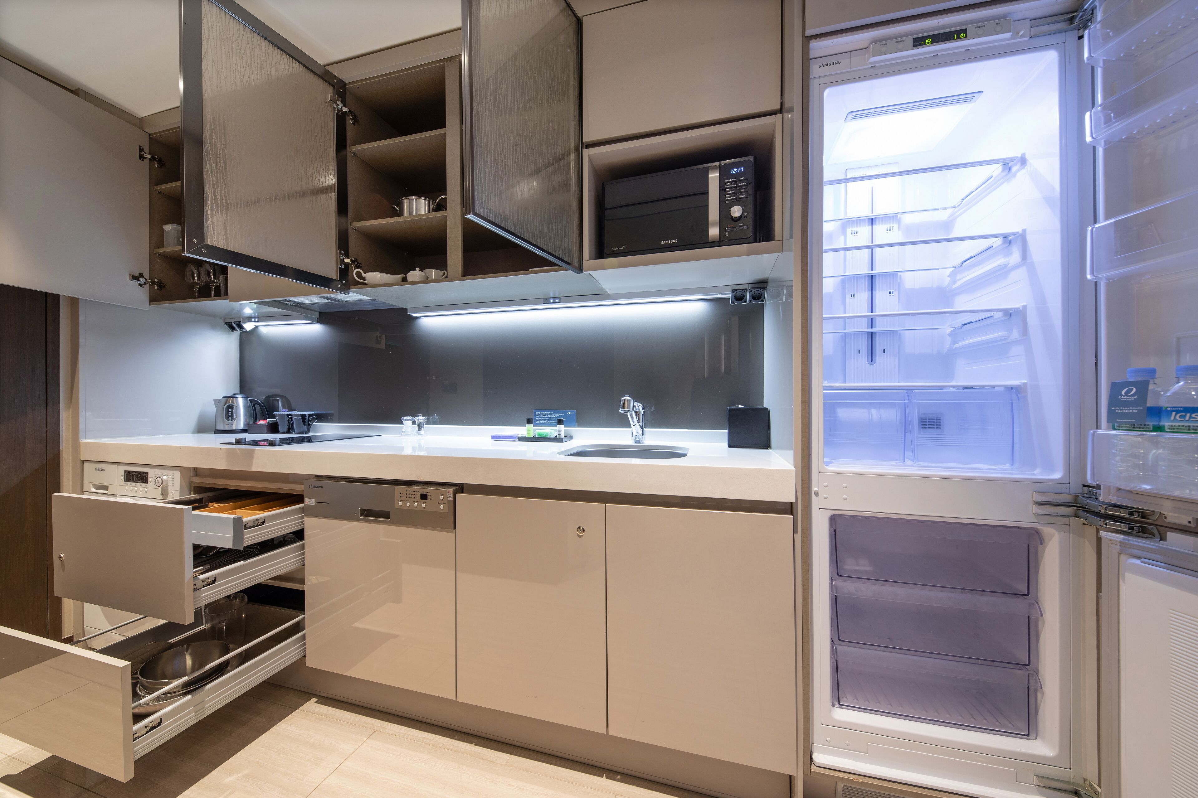 Una cucina moderna con forno a microonde integrato, lavello e lavastoviglie.