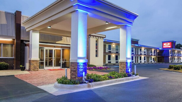 A hotel entrance with a covered area, a glass door entrance, and a visible sign for the hotel. - Econo Lodge Selma - Smithfield (Selma)