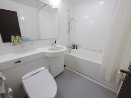 A bathroom with a toilet, sink, and bathtub. There are toiletries on the sink counter.