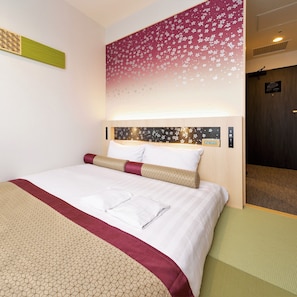 Relax in a stylishly designed room with a comfortable bed, floral-patterned headboard, and modern amenities.