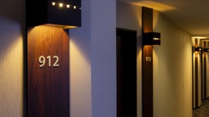 A hallway with a wooden door labeled '912' and a wall-mounted light fixture. - KOKO HOTEL Shinjuku Yotsuya (Tokyo)