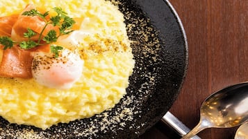 A dish with rice, salmon, and a poached egg on a black plate.