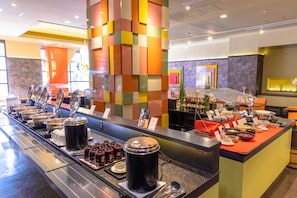 Enjoy a wide selection of food and beverages at our buffet counter, featuring a variety of dispensers and condiments.