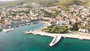An aerial view of a coastal town with a marina, white buildings, and a prominent church.