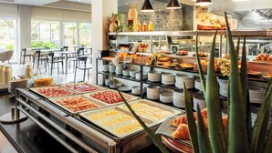A buffet area with various food options, including meats, cheeses, and fruits.