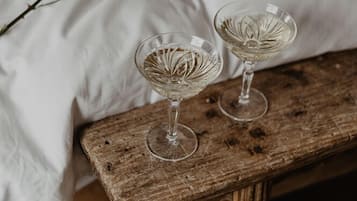 Un lit avec une literie blanche et un banc en bois.