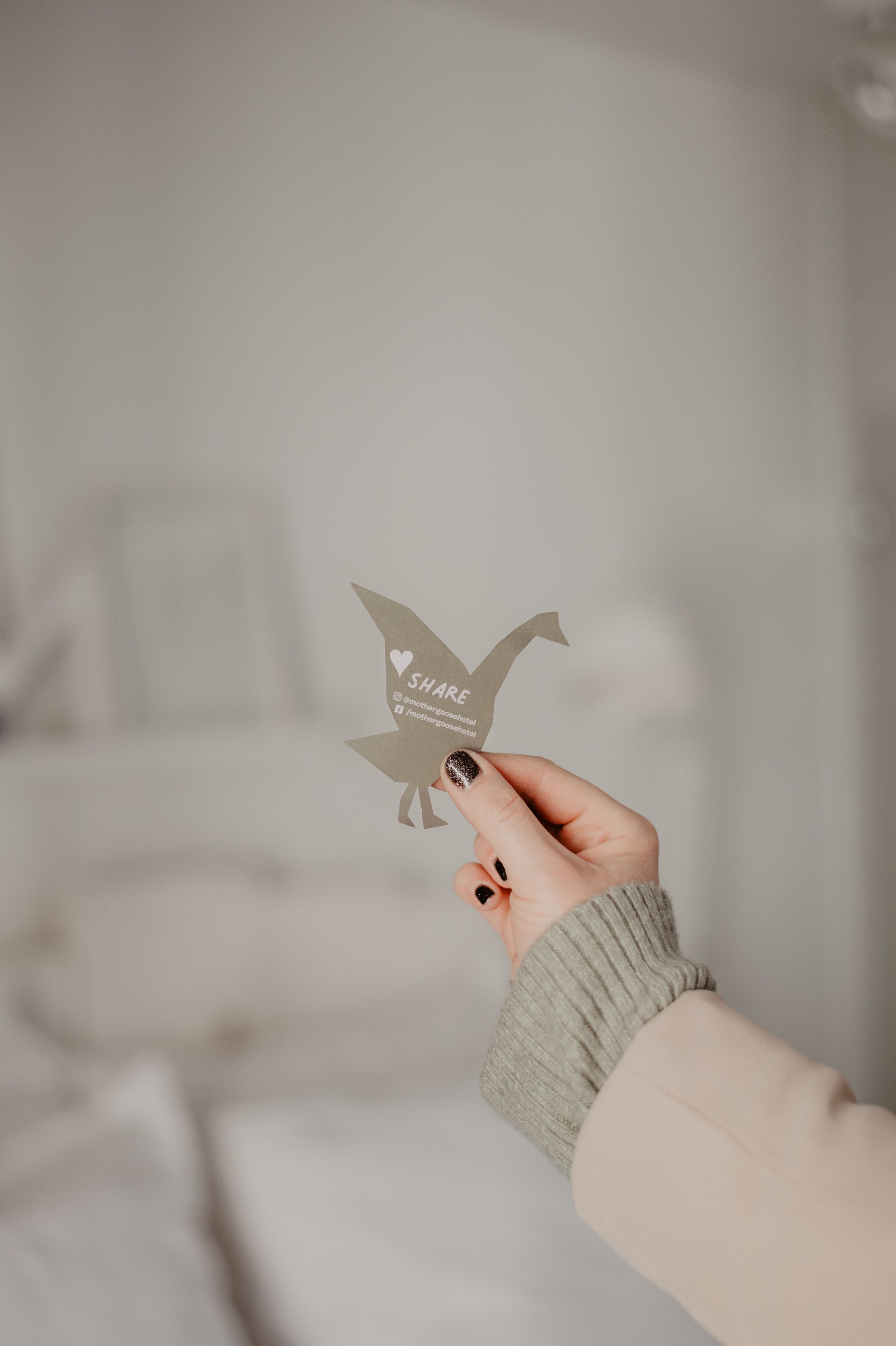 Una mano sosteniendo un avión de papel con la palabra 'SHARE' y un símbolo de corazón.