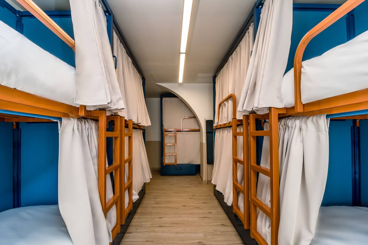 A corridor with bunk beds, wooden flooring, and a central archway.