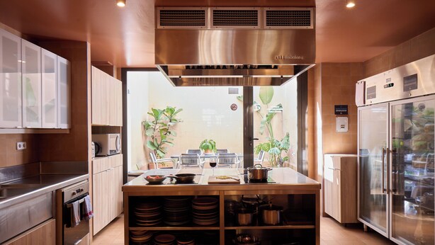 A modern kitchen with stainless steel appliances, wooden cabinets, and a central island with cooking utensils.