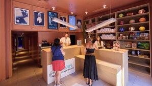 A reception area with a counter, framed pictures on the wall, and shelves with various items.