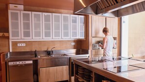 A modern kitchen with stainless steel appliances, wooden cabinets, and a large island with a sink.