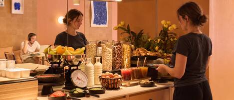 Morgenmadsbuffet med forskellige retter og en vægt.