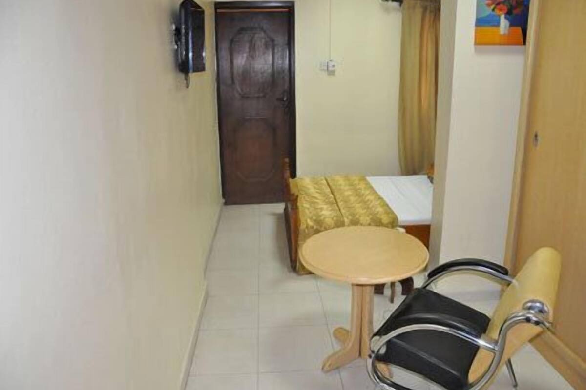 Une petite pièce comprenant un lit, une table ronde et une chaise.