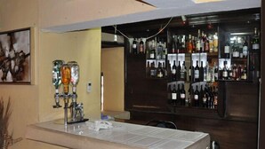 Eine Bar mit mehreren Spirituosenflaschen und einer Theke, auf der einige Flaschen und Gläser stehen.