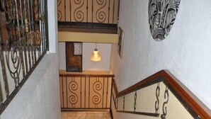 Eine Treppe mit aufwendiger Metallgeländerung und einem hölzernen Handlauf.