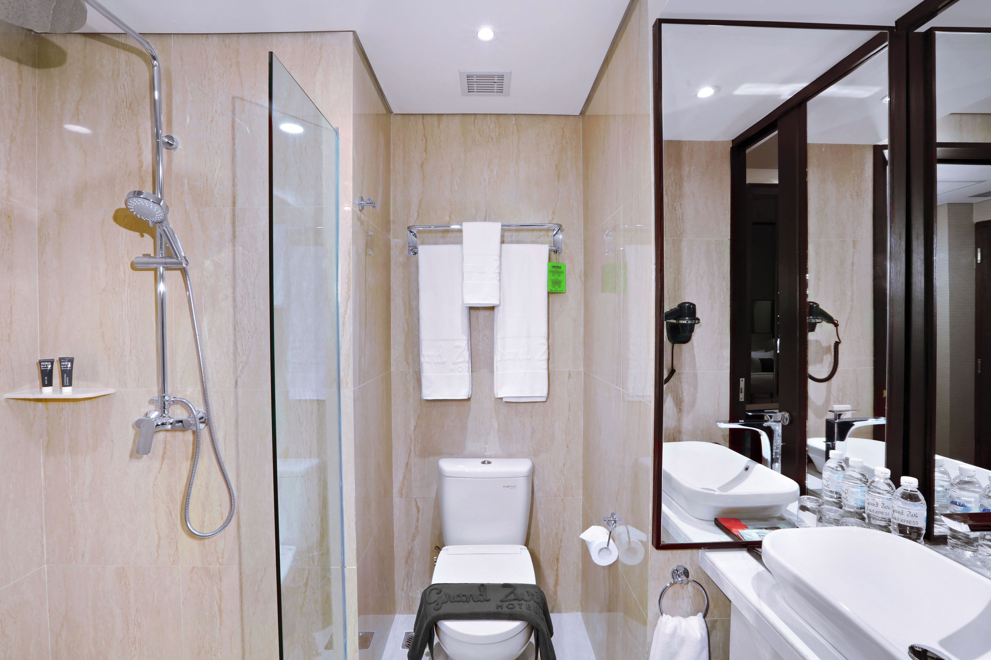 Une salle de bain moderne avec une douche à parois de verre, des toilettes et un lavabo avec un miroir.