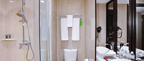 Une salle de bain moderne avec une douche à parois de verre, des toilettes et un lavabo avec un miroir.