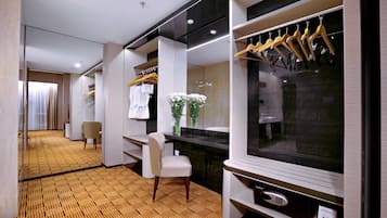 Relax in a stylish room with a large mirror, seating area, and vanity, offering a comfortable space to unwind.