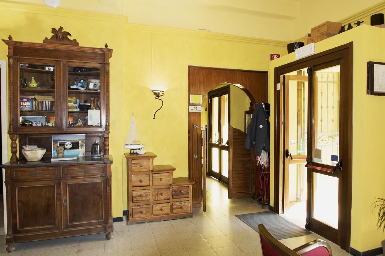 A hallway with a wooden cabinet, a small table with a lamp, and a door leading to another room.