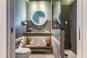 Habitación cuádruple Deluxe, vista a la ciudad | Baño | Regadera, regadera tipo lluvia, amenidades de baño ecológicas 