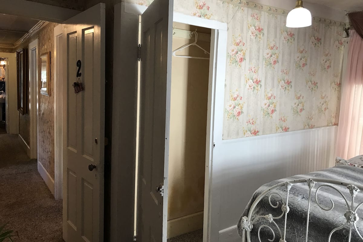 A room with a bed, a wardrobe, and a hanging wardrobe.