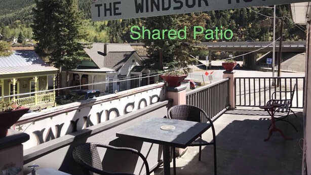A hotel sign reading "THE WINDSOR HOTEL" with a view of a shared patio area. - Historic Windsor Hotel (Silver Plume)