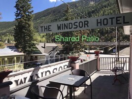 Señal de hotel que dice 'THE WINDSOR HOTEL' con vista a un patio compartido.