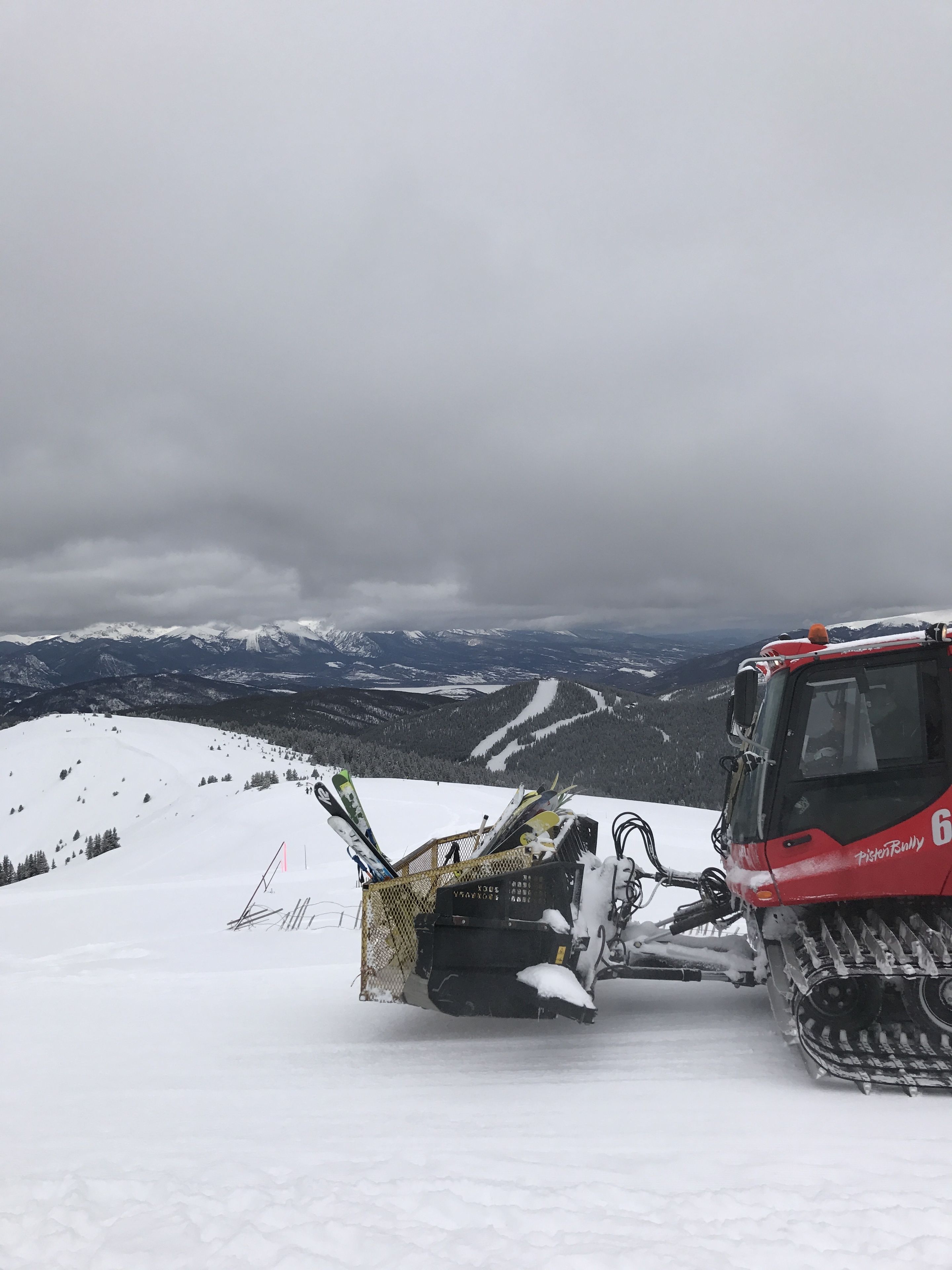 A snowmobile with skis parked on a snowy mountain.