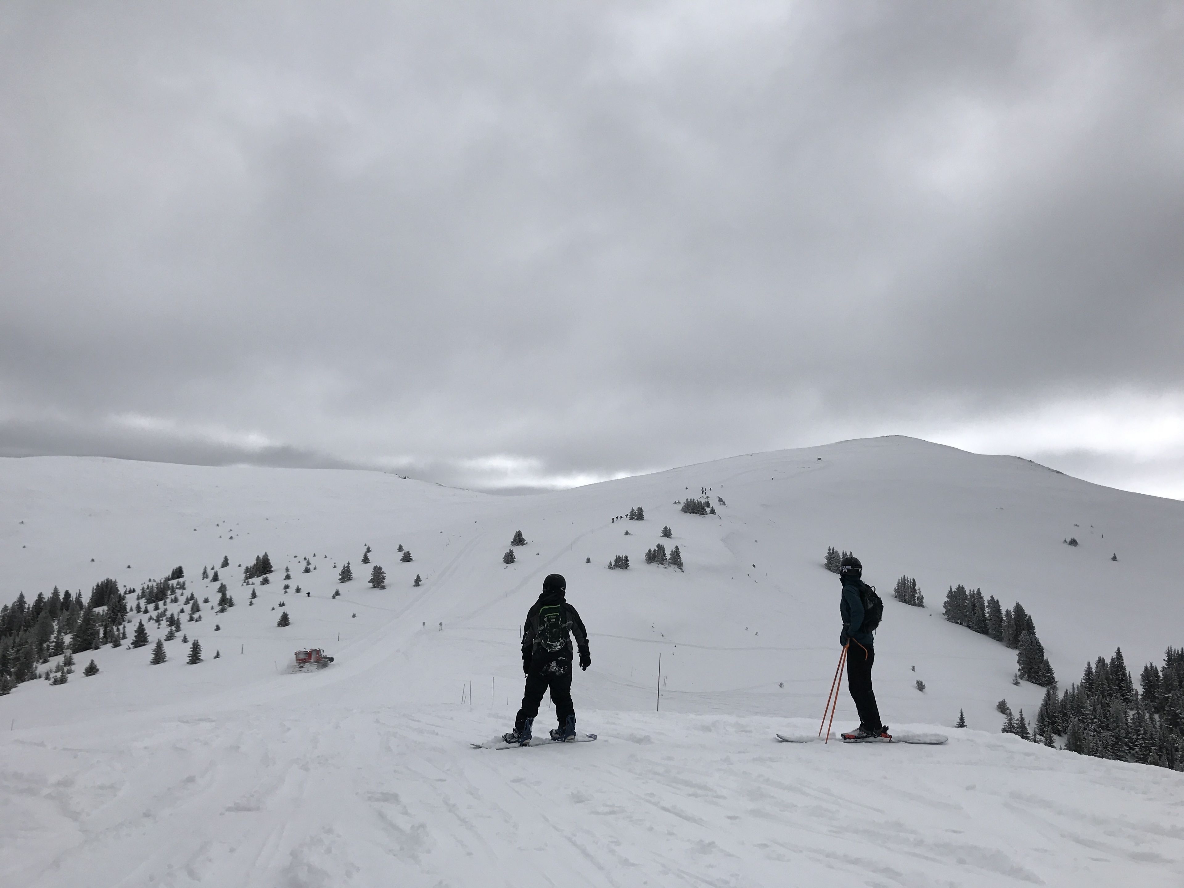 A snowy mountain slope with skiers.
