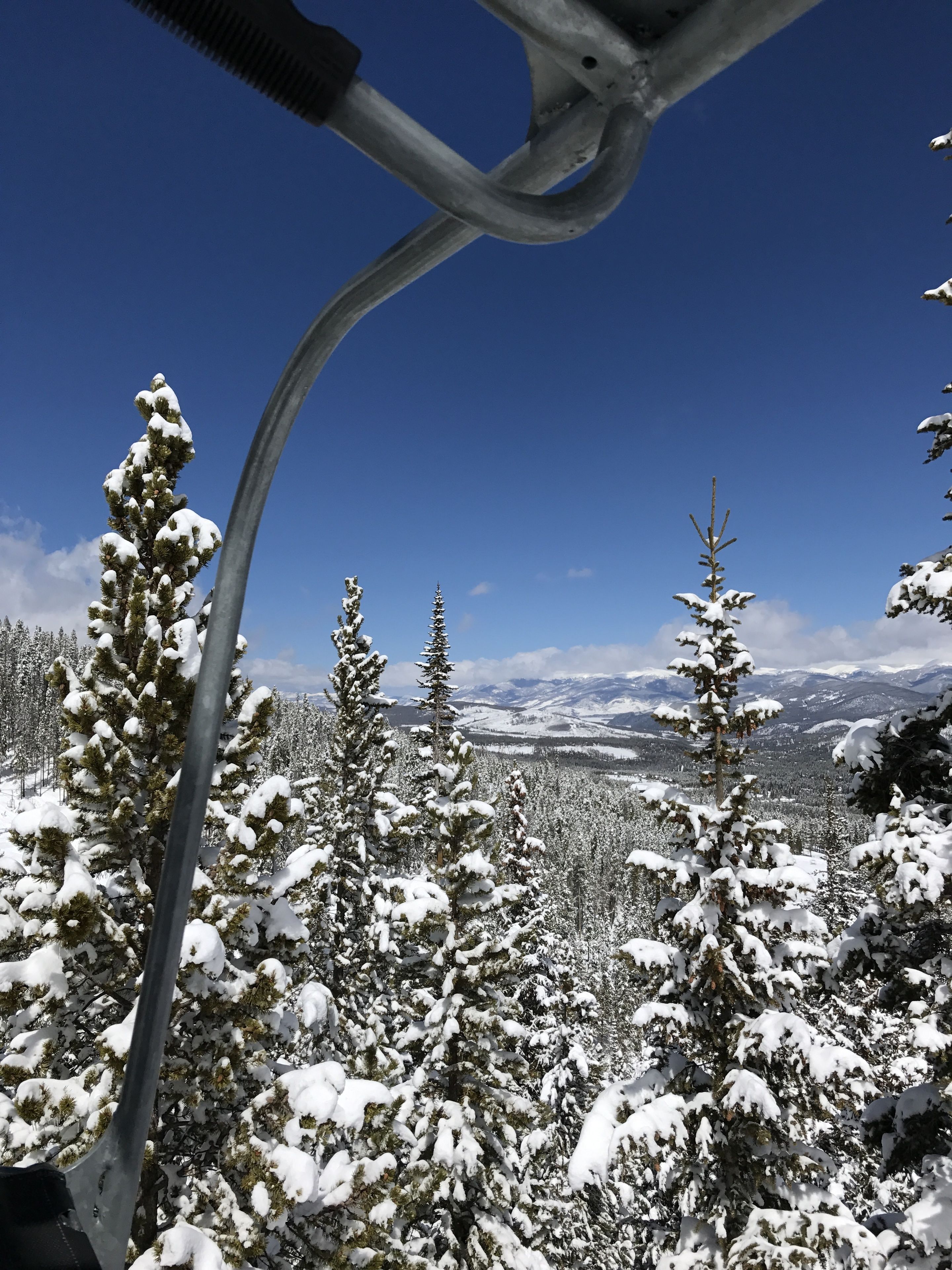 A snowy mountain landscape with a ski lift in the foreground.