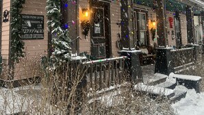 A hotel with a balcony, snow-covered exterior, and Christmas decorations. - Historic Windsor Hotel (Silver Plume)