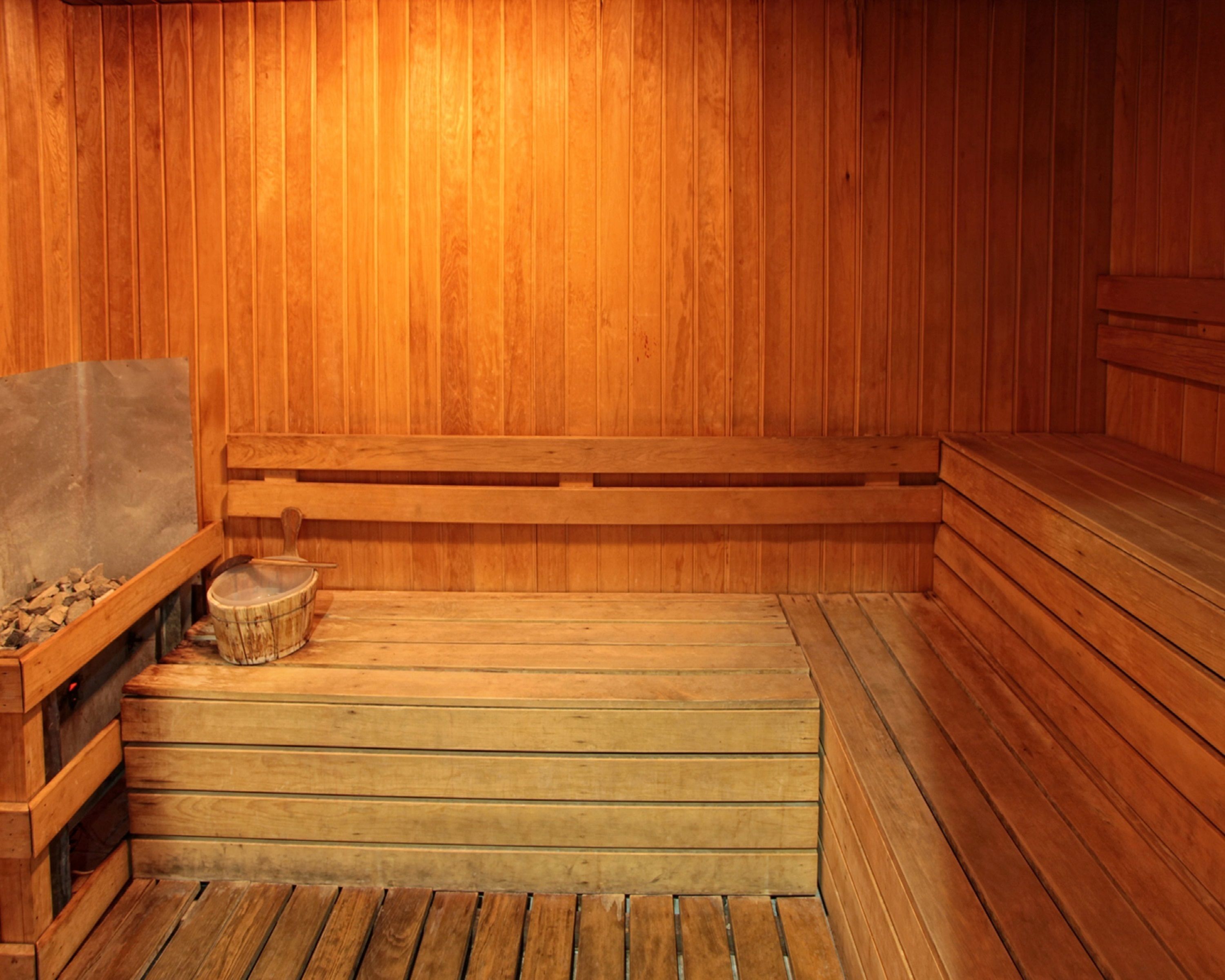 A sauna with wooden benches and a stone basin.