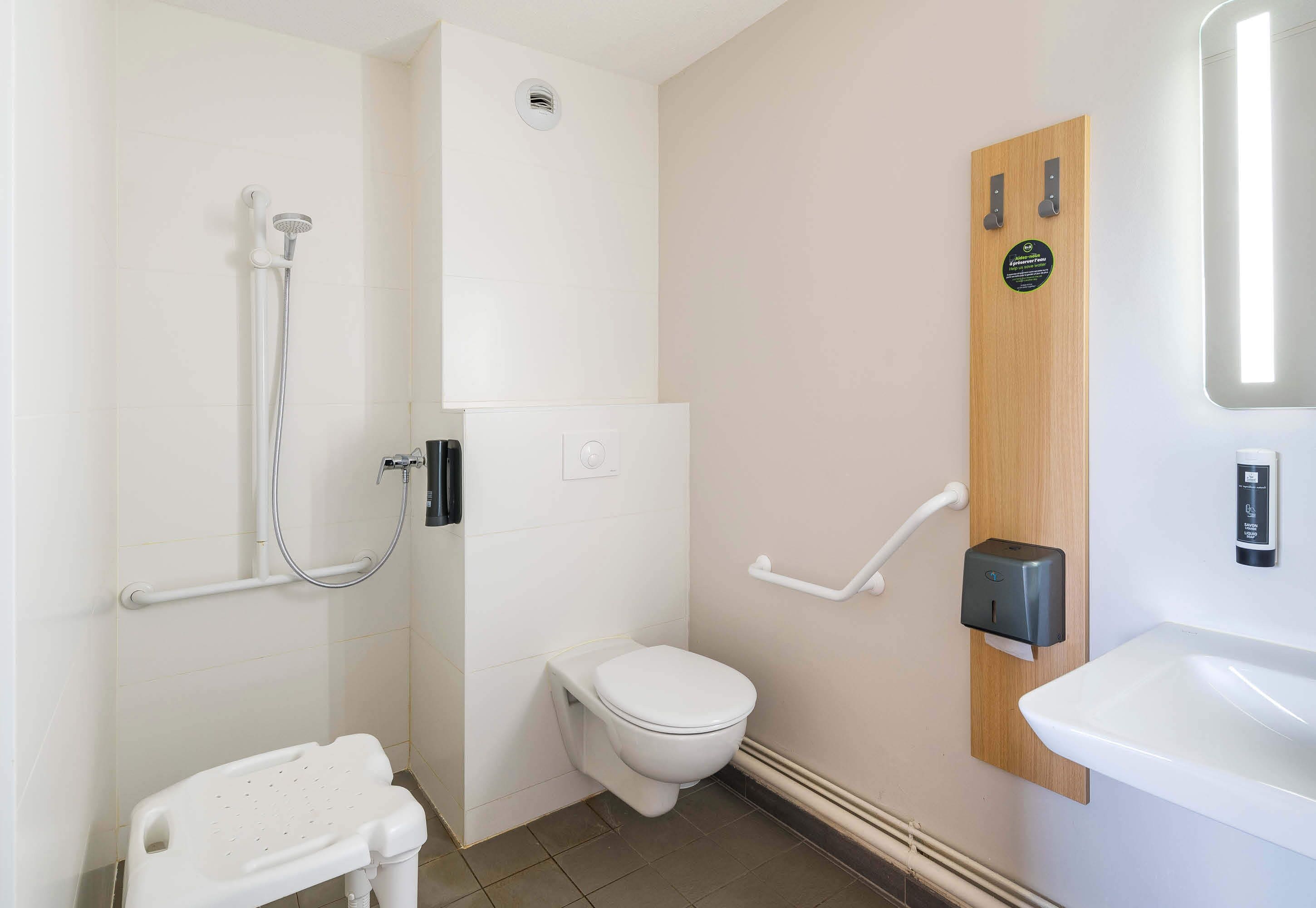 Une salle de bain moderne équipée de toilettes, d’une douche et d’un lavabo.