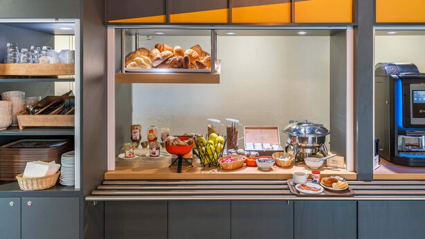 Un bufé de desayuno con diversas opciones de comida, como pasteles, frutas y bebidas.