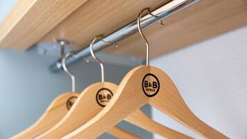 Wooden hangers with a logo, hanging on a metal rod.