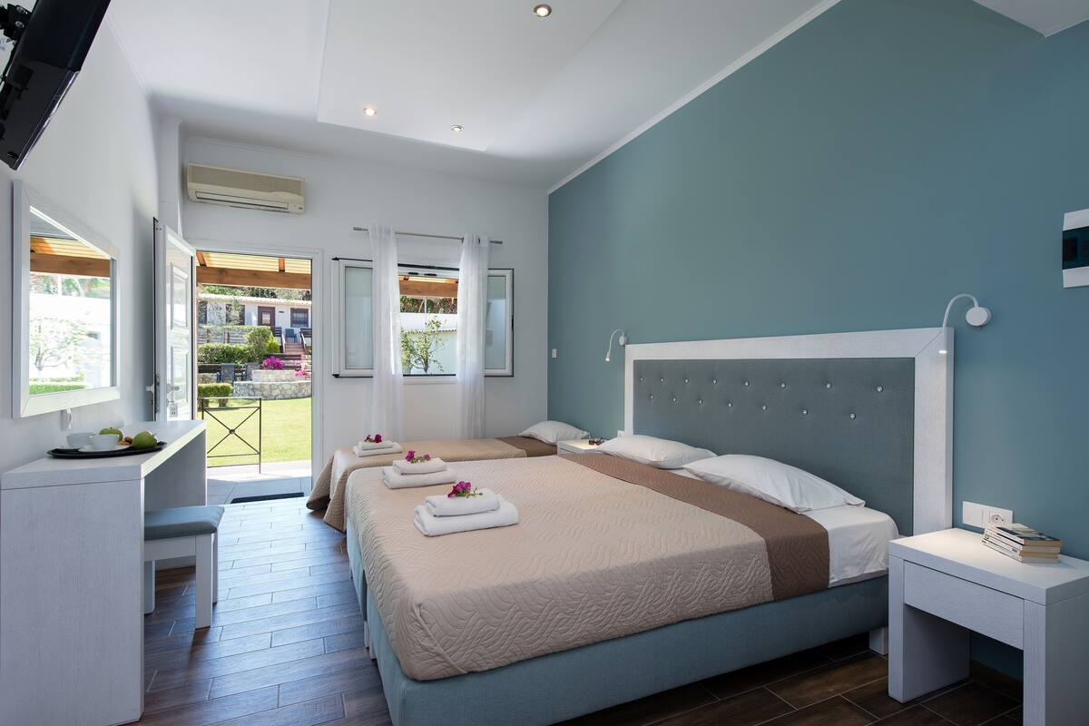 A hotel room with a large bed, a desk, and a view of the outdoors.