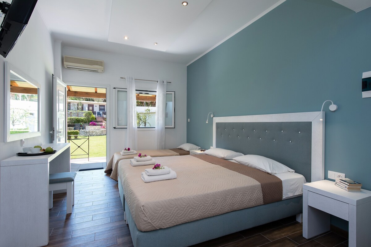 A hotel room with a large bed, a desk, and a view of the outdoors.