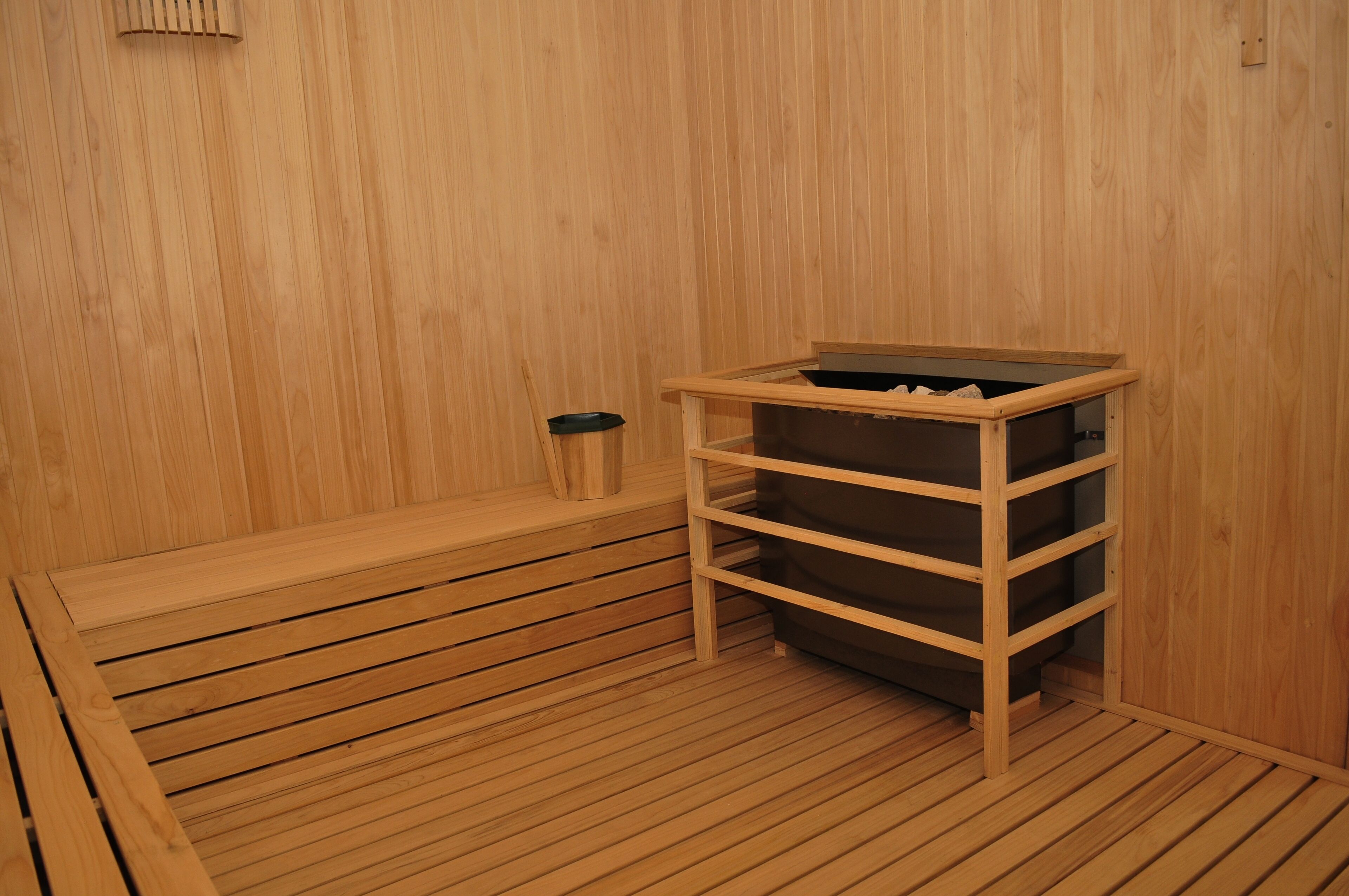 A wooden sauna with a bench and a shelf unit.