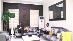 A modern living room with two sofas, a coffee table, and a large mirror. - Palazzo Dumont Hotel (Lekki)