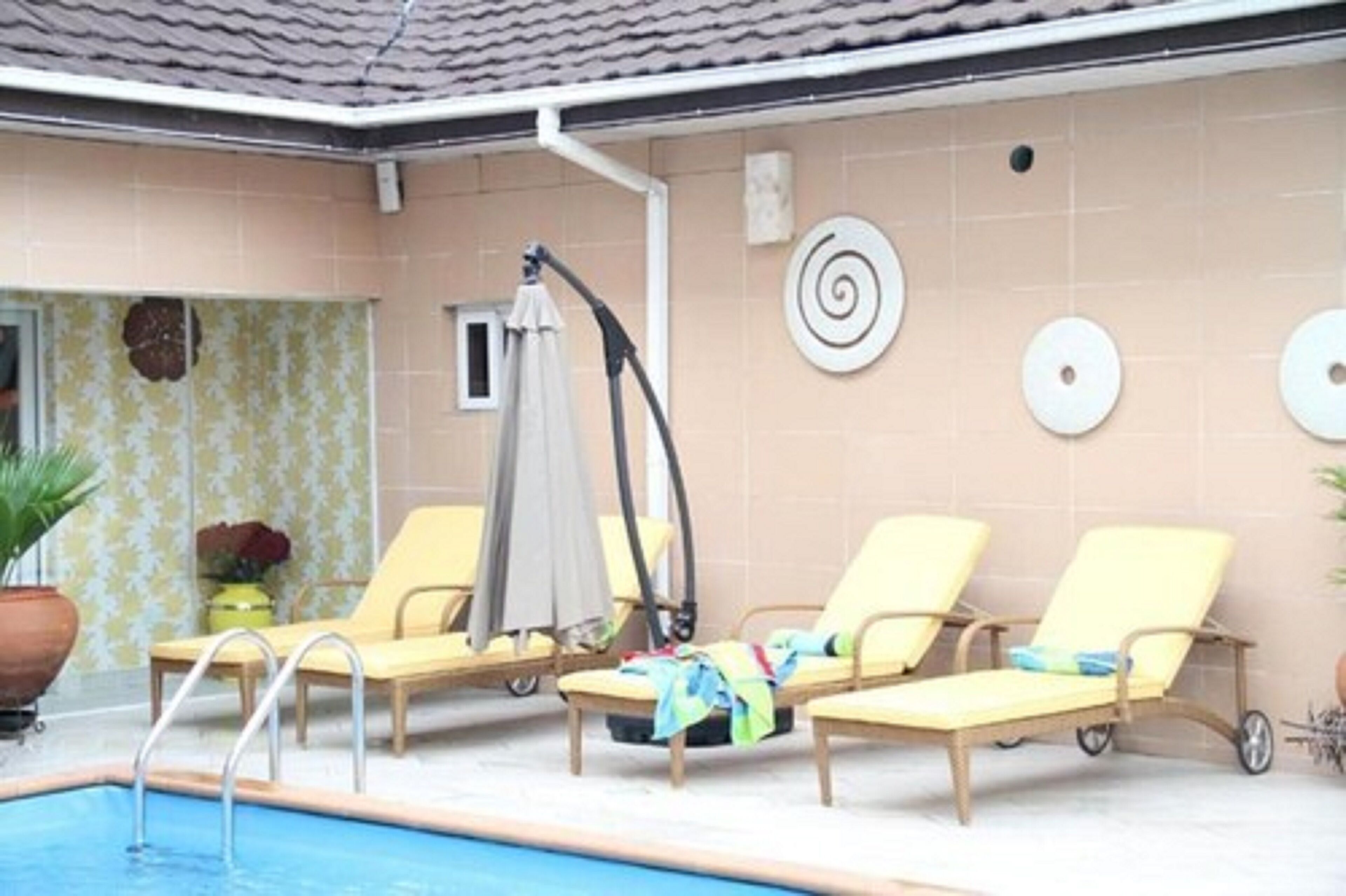 Un espace piscine avec des chaises longues et une fontaine.