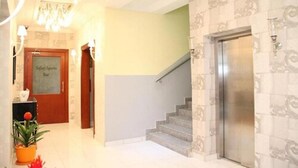 A hotel lobby with a staircase, a reception desk, and a bar. - Palazzo Dumont Hotel (Lekki)