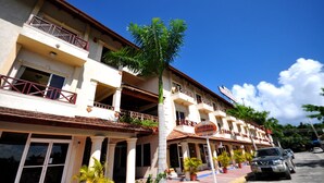 Un hotel de varios pisos con balcones, un restaurante y un letrero que indica que es hotel y restaurante.