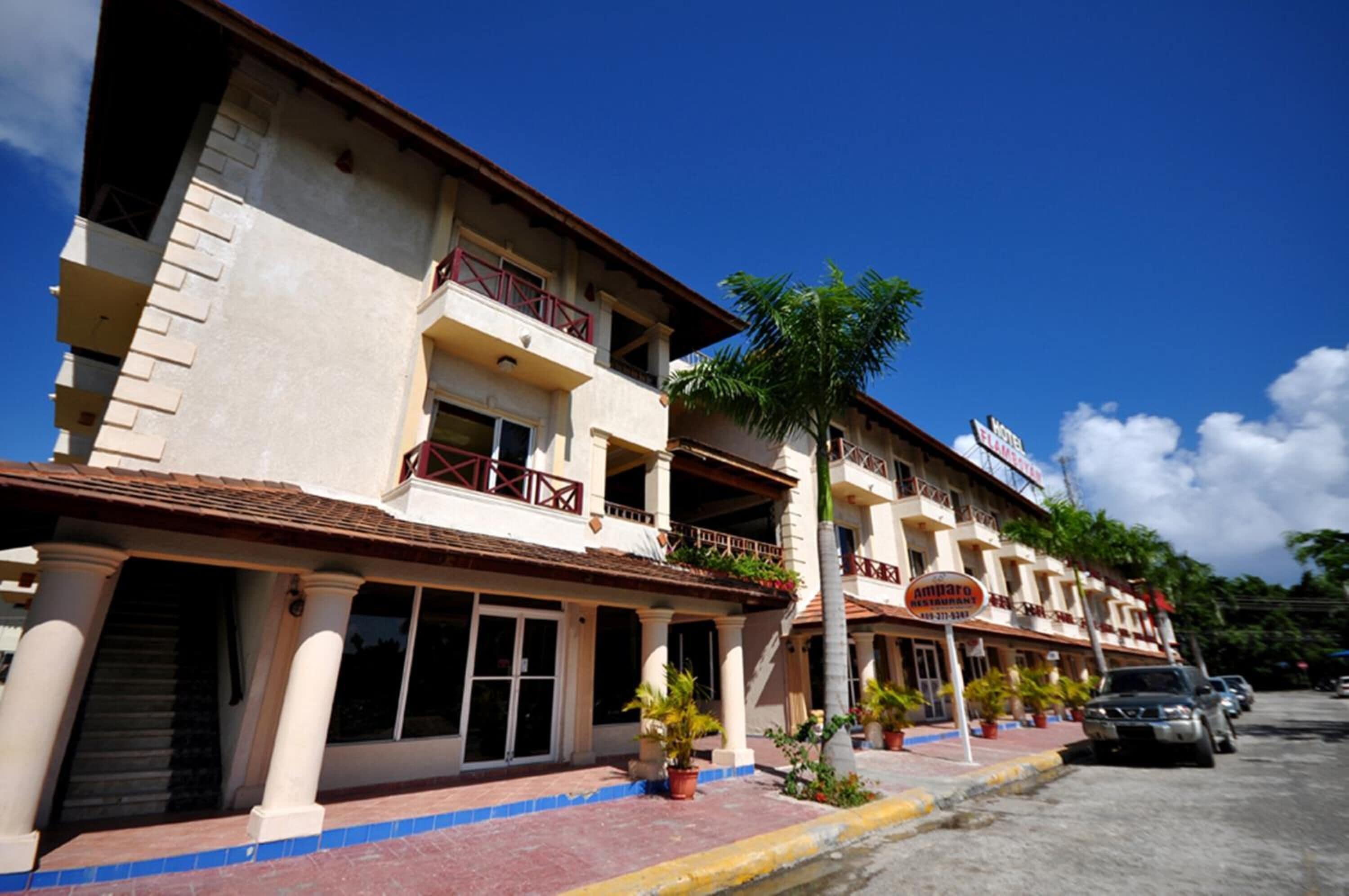 A multi-story hotel with balconies, a tiled roof, and a sign indicating it is a restaurant.