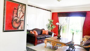 Una sala de estar con un sofá, una mesa de centro y un cuadro en la pared.