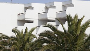 A modern building with multiple balconies and a flat roof, surrounded by palm trees. - Les Rivages d'Ulysse (Le Grau-Du-Roi)