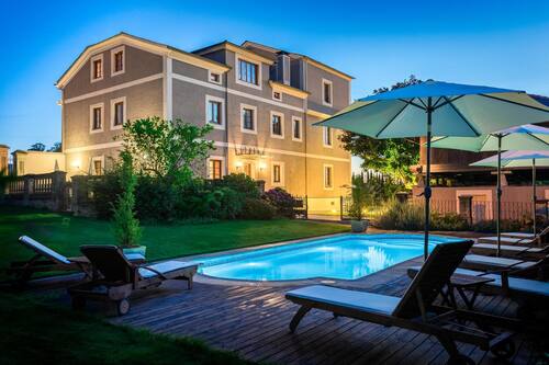 Una piscina al aire libre, sombrillas, tumbonas