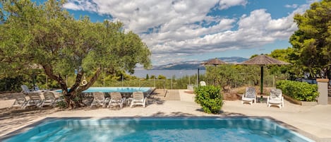 Utomhuspool, parasoller och solstolar