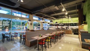 A modern restaurant with a bar area, high ceilings, and large windows. - Zuri Express Lippo Cikarang (Bekasi)