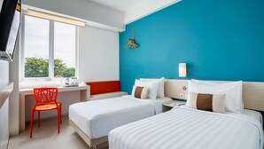 A hotel room with two beds, a desk, a chair, and a large window.